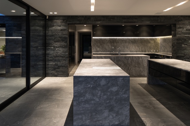 The monochromatic scheme and veins from the stone complement the silver and grey of the walls and granite floors.