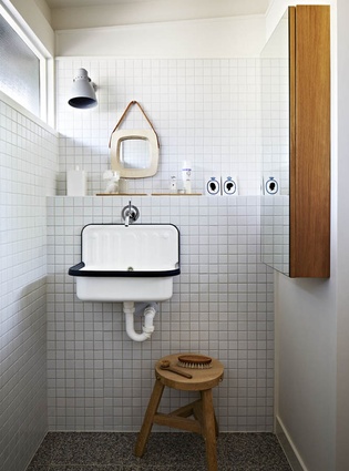 A tiled bathroom has an industrial feel. 