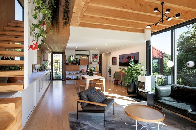 A long-view of the main living area with floating staircase and living wall visible to the left.