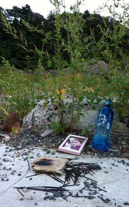 A photo, incense, and Japanese liquor form a makeshift shrine.