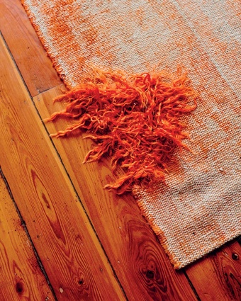 Vintage rug: "This is an old, worn-down Turkish rug that has been re-dyed in bright orange. We purchased it like that from a great shop called Loom Rugs".