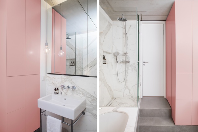 The black box of the bathroom’s external walls hides a soft pink and marble room inside.