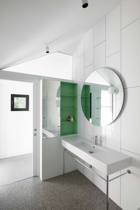 Gentle green accents are a playful touch in the pared- back bathrooms, where heritage-inspired fixtures add character.