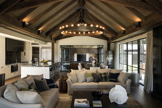 The living and dining area opens to a covered outdoor courtyard space. The Blue Marinache stone in the kitchen resembles the stones on the nearby waterfront. The chandelier is Ralph Lauren from <a 
href="https://cavitco.com/product-by-brand/ralph-lauren/lighting/roark-40-modular-ring-chandelier/"style="color:#3386FF"target="_blank"><u>cavitco.com</u></a>.