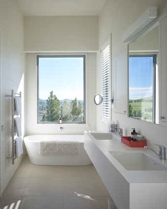 In the master suite, a freestanding bath offers a view of the pony club.