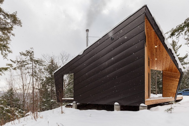 Cabin on a Rock, New Hampshire. Black metal and a pre-manufactured timber frame accentuates the strong lines of this angular cabin that boasts a minimal but cosy interior.