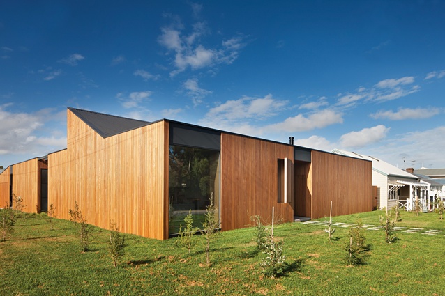 A playful triangular protrusion references the gable roofs of the surrounding houses.