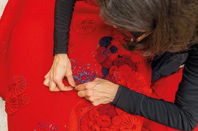 Project director Kirin Makker embroiders French knots into the footstool.