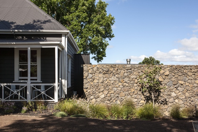 A scoria wall creates a strong contrast beside the old bungalow at the front of the property. 
