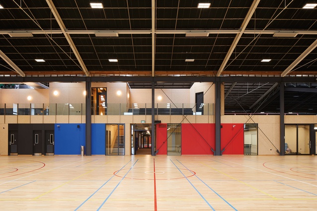 Looking across the gymnasium to the classroom blocks, which are constructed out of strandboard-lined prefabricated walls and stacked in two storeys.