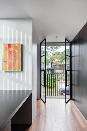 Black joinery, windows, doors and finishes provide consistency and anchor the space. Artwork: John Reid.