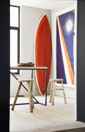 A longboard and a framed flag add colour and beach chic to an otherwise pared-back aesthetic.