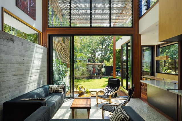 The garden room opens to the outdoors, visually linked by the rough concrete wall.