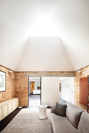 A geometric skylight is positioned at the apex of a new roof and ceiling that “float” above the living room walls. Artwork (L–R): Sarrita King, Ann Thomson.