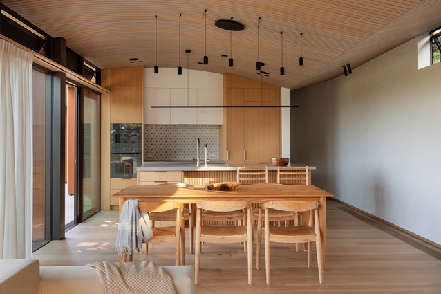 The house’s unique ceiling creates a sheltering note for the living, dining and sleeping spaces.