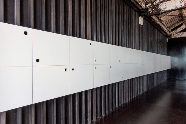 Sound insulation is hidden by steel battens and a long row of staff lockers.