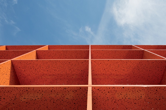 The orange façade is perforated with a textured orange-peel finish. 