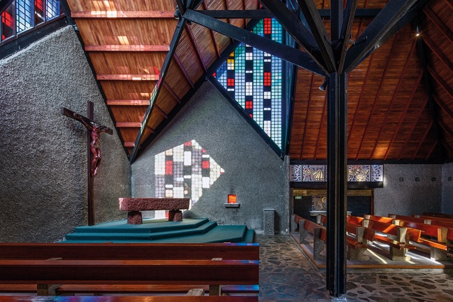 The massive stone altar is dried-blood red. A slightly larger-than-life-sized mahogany corpus, with a recognisable Polynesian form, overlooks from a large wooden crucifix.