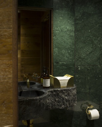 Each bespoke bathroom features a curved, tooled marble sink handcrafted in Italy, and brass accessories.