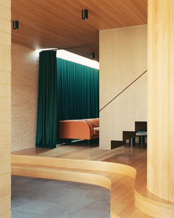 A raised timber plinth, wool curtain and suspended steel stair lend a sense of theatre to the lounge.