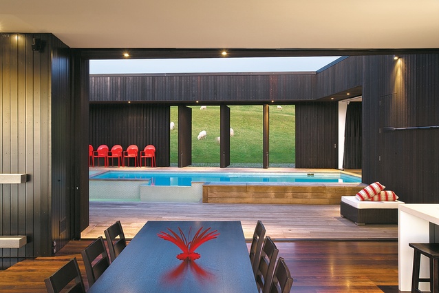 Looking from the dining area to the courtyard and pool. Open screens reveal the farmed slopes on the landward side of the house.
