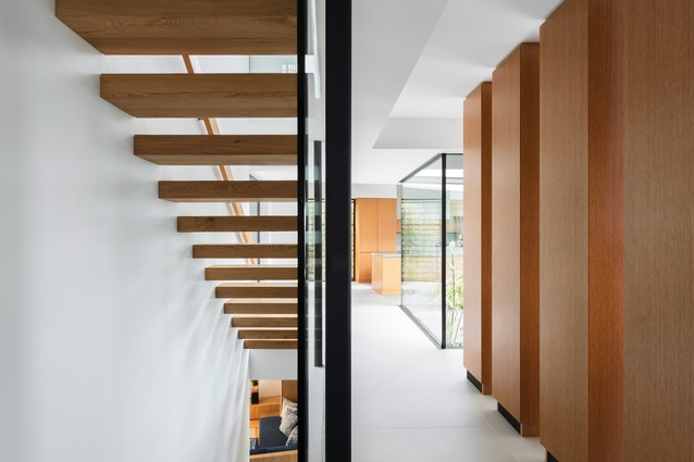 Cantilevered timber stairs to the upper and lower levels are shielded from the living area by a series of timber box forms that are storage cupboards and service risers.