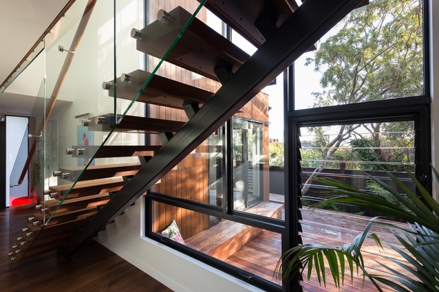 The black edging and stairs create an intense contrast against the warm hues of the red cedar.