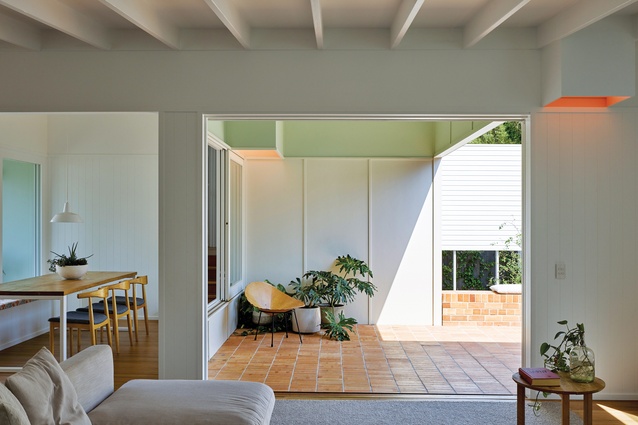 Wide windows and built-in seating foster a sociable connection through the home to the front garden.