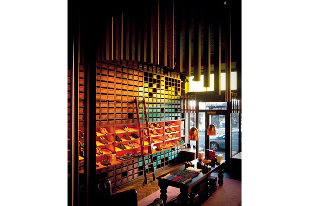 The designer used vertical timber panels to create a cosy atmosphere in the space, which has a tall Victorian ceiling.