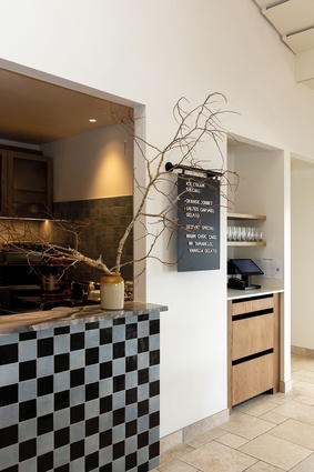 A checkered-tile servery draws the eye to the kitchen, encouraging guests to engage with the culinary artistry on show.