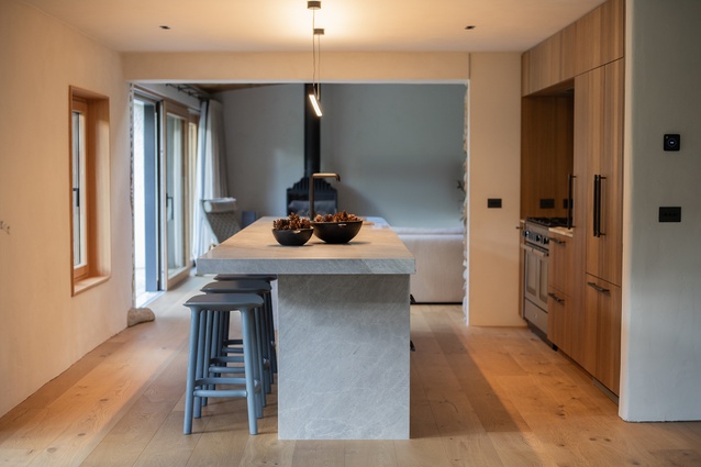 Where the kitchen meets the living space, the original schist walls are revealed.