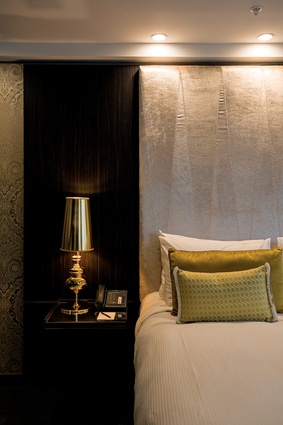 A suite with a velvet headrest, golden fabrics and light-coloured shelves.