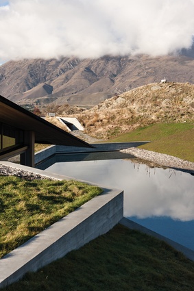 Queenstown home. The palette of this stunning house includes polished and board-formed concrete, stone, glass and water to create structural and aesthetic beauty.