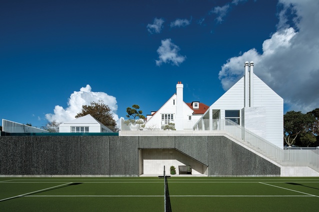 Concrete wall panelling for the tennis court contrasts with a combination of sandstone and white jade stone on the home’s exterior.