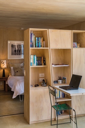First Light House: The main bedroom is open to the rest of the interior but visually separated by a study-and-storage furniture unit, which acts as a room divider.
