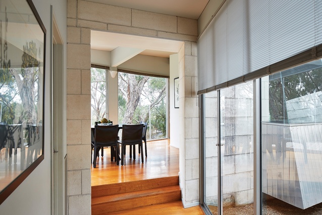While the kitchen looks inward, the dining space is close to the windows and offers access to a wedge-shaped deck