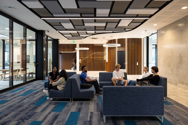A meeting lounge is flanked by soft lighting and wood panelling.