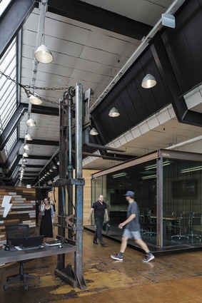 Other key devices include moveable room dividers fitted with acoustic insulation and feature walls made out of pieces of timber salvaged form the existing building.