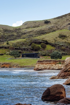 Storm Cottage: Located on the east coast of Great Barrier Island, this 100m<sup>2</sup> black, rough-sawn-timber box faces the sea.