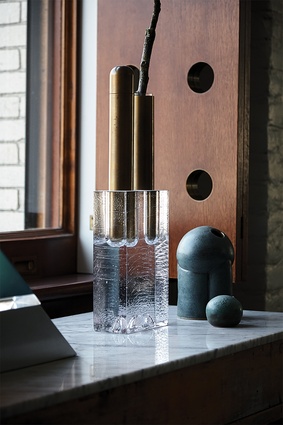 Sleek finishes, such as the brass and cast-crystal Block Double Vase by Apparatus, can be found in the dining room. 