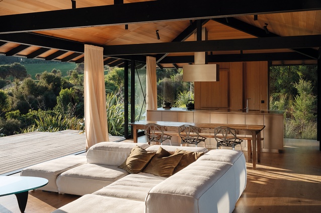 Living and dining areas and kitchen unit, with the west-facing deck at left. Several long beams are the only deviations from NZS 3604.