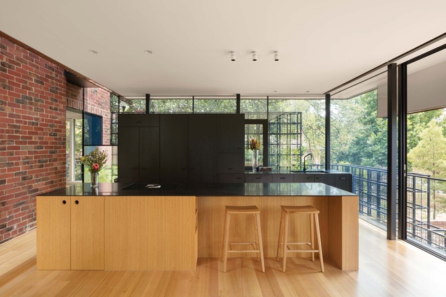 A wall of black-stained cabinetry lines the kitchen’s western edge, affording it privacy from the neighbouring walkway.