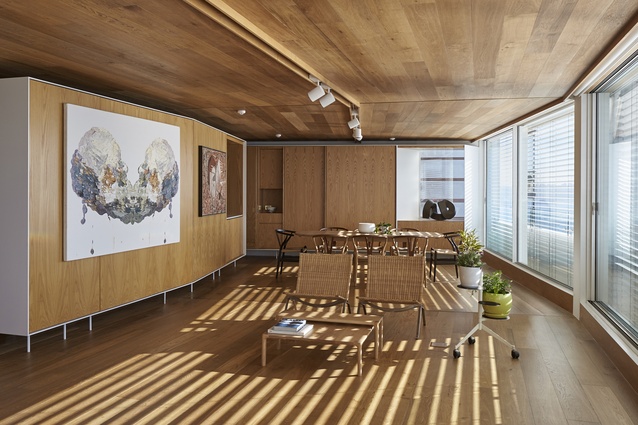 A lighting track follows the kinking geometry of the room, with the floorboards and ceiling emphasising the bending of the space to give a sense of elongation. 