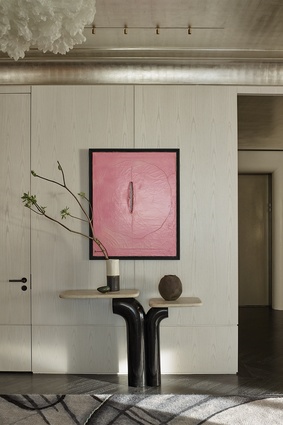 Lucio Fontana’s <em>Concetto Spaziale</em> pops against walls panelled in flat-cut, custom-bleached ash, finished with just a hint of charcoal. Eric Schmitt’s Dragee Console of patinated bronze and marble makes a strong, functional statement below. 