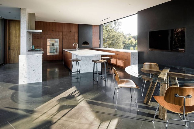 The kitchen opens up to the landscape through a sliding window. 