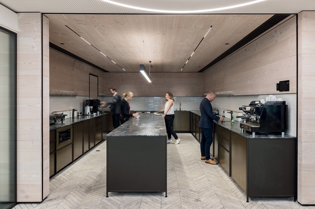 The dark steel, stone and timber areas of the library and staff kitchen contrast with the glittery bright central hub.