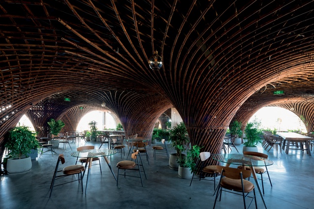 The insertion of a woven bamboo structure on the upper level of this colonial-style building in Vinh, a city in North Vietnam, creates a unique experience for café patrons.