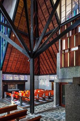 The ceiling's exposed rafters and matai sarking contrast with the concrete walls and serpentine marble floor.