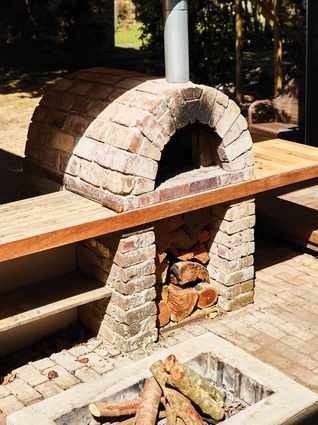 A brick fire pit and courtyard form the social heart of the home, tying the other spaces together.