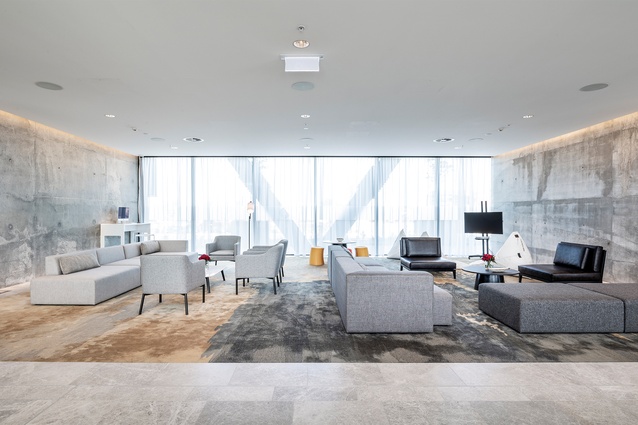 The exposed concrete walls set a grey tone to the materiality of the space. “Organic land contours sweep the floors, interrupting the monotony,” says Pelham of flooring finishes.